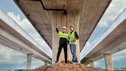 Engenheiro apontando para uma ponte durante o serviço