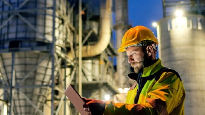 Homem segurando um tablet em planta industrial - Moody Brasil