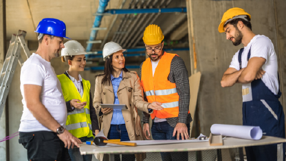 Pessoas em uma gestão de obras discutindo projeto
