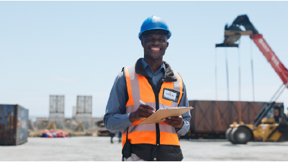 Homem posando sorridente para foto em obra de porto para o serviço de inspeção acreditada de projetos